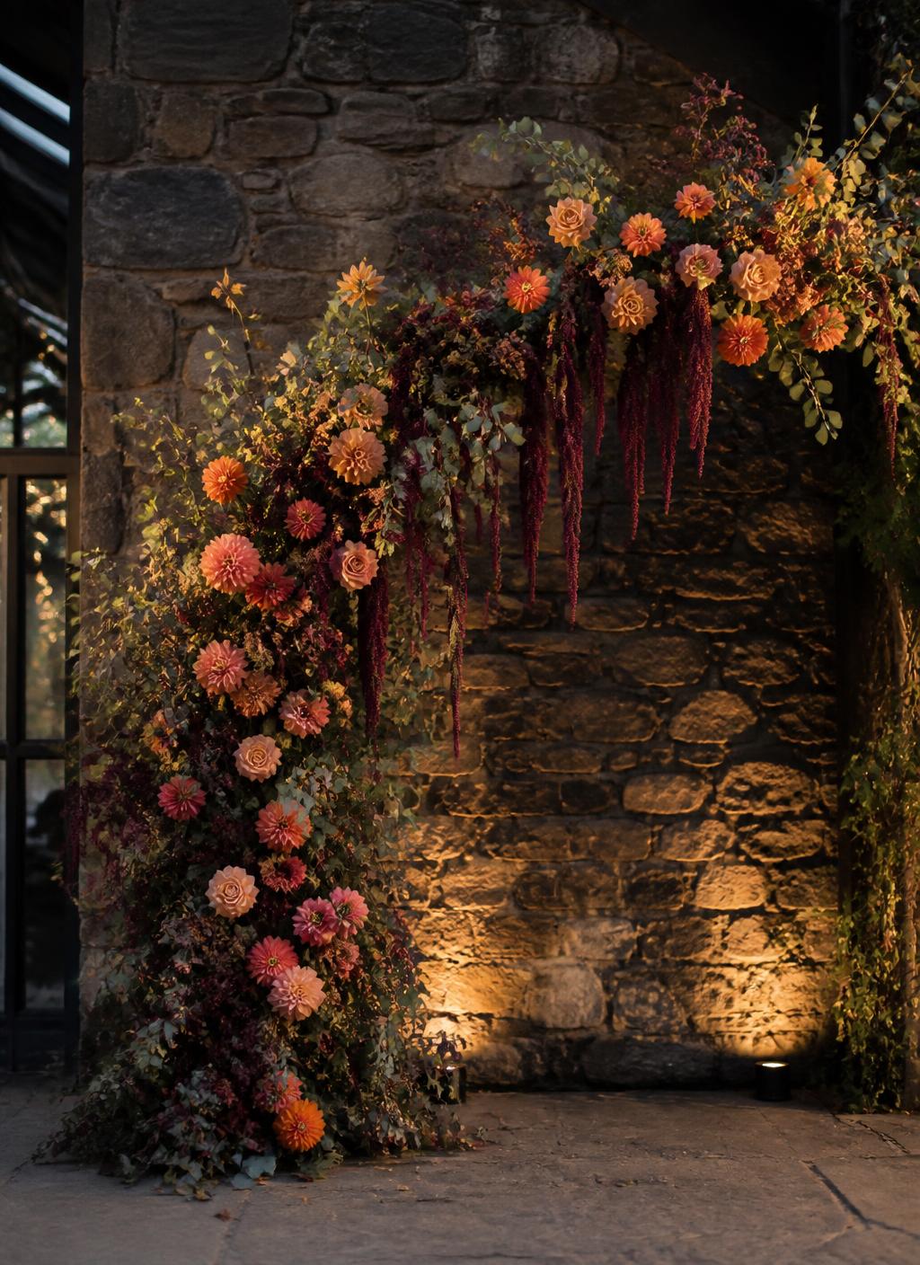 Autumn floral arch against a stone barn wall